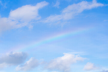 Fototapeta na wymiar Blue sky with clouds and rainbow 