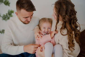The theme of Christmas and New Year. Parents and children at home play under the Christmas tree. Joyful laughter and emotions. Christmas 2022.