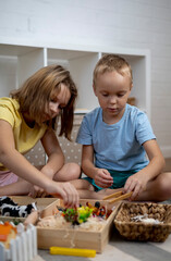 Touch drawer with rainbow rice inside. Children hand touch the texture. Montessori material concept for toddlers.