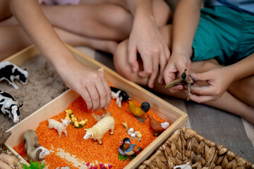 Touch drawer with rainbow rice inside. Children hand touch the texture. Montessori material concept...