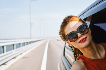 woman looking out of car window wearing sunglasses travel lifestyle