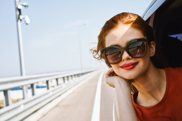 cheerful woman peeking out of the car window trip adventure lifestyle