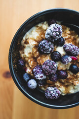 vegan oatmeal with cinnamon ixed berries and maple syrup, healthy plant-based food