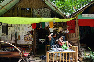 Thai man tattoo artist people write drawing tattoo on back of foreign travelers men travel visit rest relax at local tattoo shop at Ao Nang Railay bay island on April 23, 2011 in Krabi, Thailand