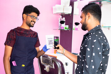 Customer scanig QR code in smartphone for making payment to baber at haircare shop - concept of Ditgital payment, Cashless technology, Recommending E pay and contactless payment Using E wallet. - Powered by Adobe