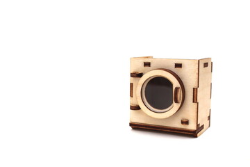 Wooden children`s toy washing machine assembled from plywood on a white isolated background