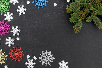 Christmas background with snowflakes of different sizes on a black background with place for text.
