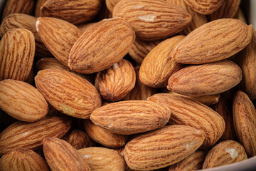 Closeup on scattered almond nuts background texture