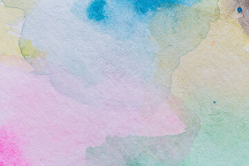 Macro close-up of an abstract multicolored yet pale watercolor gradient fill background with watercolour stains. High resolution full frame textured white paper background.