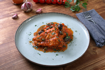 filetti di pesce in salsa di pomodoro olive e capperi