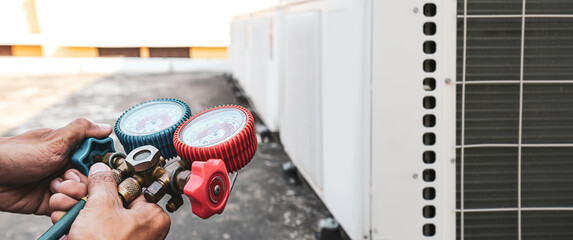 Heating and Air Conditioning, HVAC AC system service technician using measuring manifold gauge...