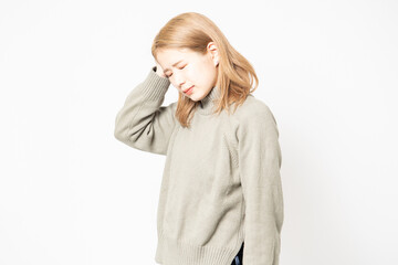 頭痛で痛がっているセーターを着た若い女性