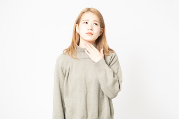風邪をひいて喉が痛いセーターを着た若い女性