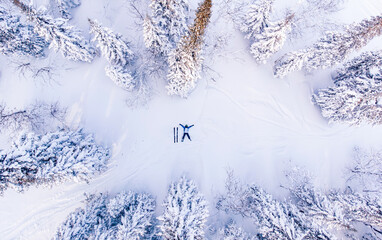 Lost skier signals SOS help for rescue helicopter in winter forest