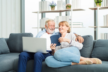 Elderly couple sitting and using laptop with happy and romantic emotion.