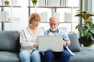 Senior woman teaching old man about laptop and he get confuse from technology.
