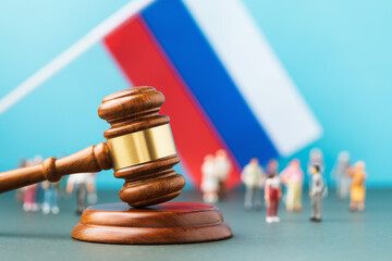 Judge gavel, against the background of a blurred flag and toy plastic men, the concept of...