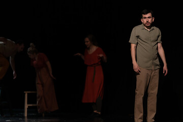 Actors and actresses perform a modern performance on the stage of the theater.