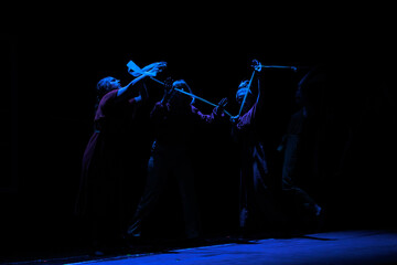 Actors and actresses perform a modern performance on the stage of the theater.