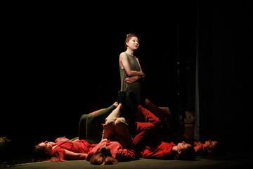 Actors and actresses perform a modern performance on the stage of the theater.