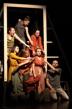 Actors and actresses perform a modern performance on the stage of the theater.