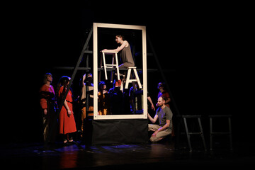 Actors and actresses perform a modern performance on the stage of the theater.