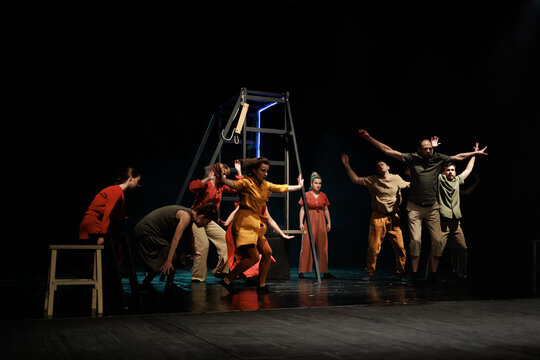 Actors and actresses perform a modern performance on the stage of the theater.