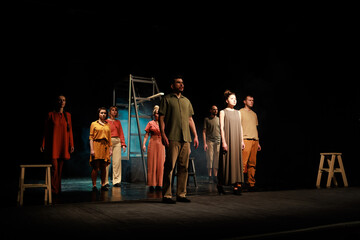 Actors and actresses perform a modern performance on the stage of the theater.