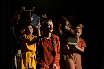 Actors and actresses perform a modern performance on the stage of the theater.