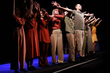 Actors and actresses perform a modern performance on the stage of the theater.