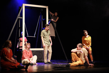 Actors and actresses perform a modern performance on the stage of the theater.