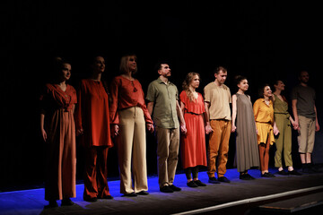 Actors and actresses perform a modern performance on the stage of the theater.