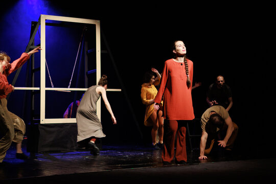 Actors and actresses perform a modern performance on the stage of the theater.