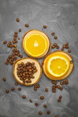 Top view of three wooden stands with coffee beans and two orange slices