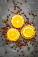 Juicy orange slices lie on three small wooden stands, roasted coffee beans around