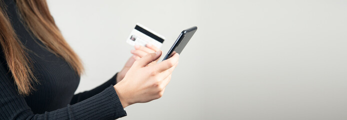 woman is holding credit card and smart phone