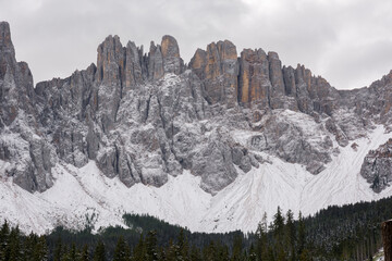 trees, mountain paths under the first snow on the lake of carezza in trentino alto adige in italy