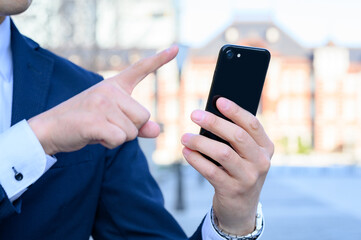 スマートフォンを操作する男性の手元