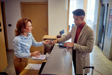 Man paying with card to a female receptionist