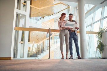 Businesspeople laughing while working at company lobby