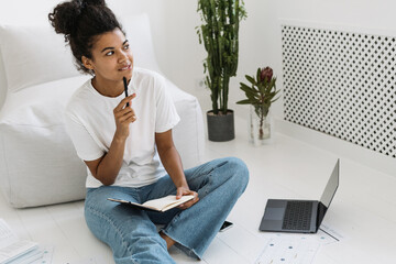 Young and thoughtful millennial girl doing homework