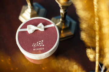 Gift box on wooden backdrop. Striped ribbon bow on present. Background