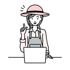 デスクで座ってPCを開いて何かひらめいた農家の女性