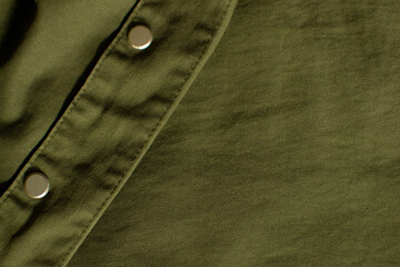 Part of olive green military uniform fabric with metal buttons