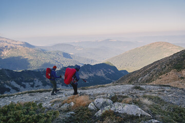 Fototapeta na wymiar Tourists with backpacks at the top of the ridge. Ukrainian Carpathian mountains. Chornohora ridge.