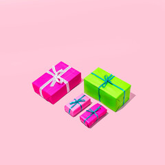 Christmas and party gifts in pink and green colors. Minimal holiday composition on a pink background.