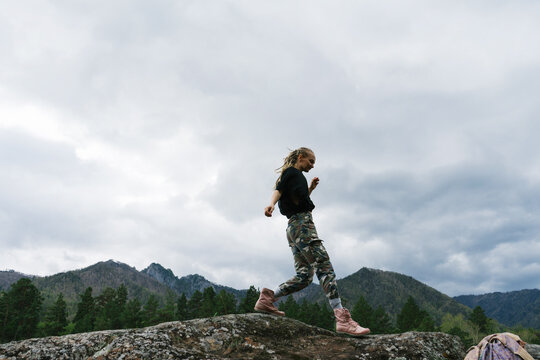 Woman walking on  rocky slope in mountains