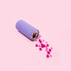 Purple canned drink with spilled beads. Christmas trendy idea for Holiday parties. Minimal composition.