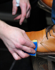 Obraz na płótnie Canvas Shoeshiner polishing client boots