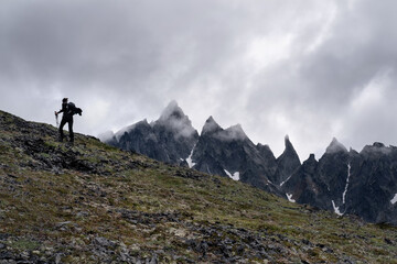 Obraz premium Silhouette of hiker female walking in the mountains. Climbing peak, trekking in Kamchatka